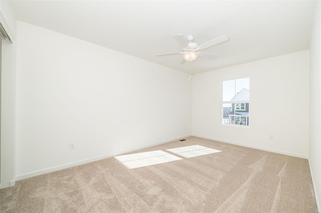 unfurnished room with ceiling fan and light carpet