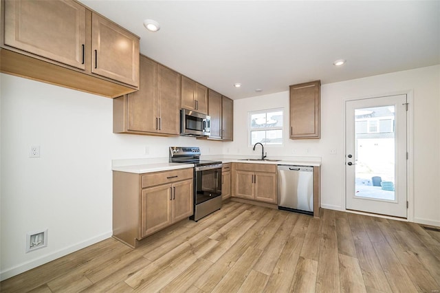 kitchen with sink, appliances with stainless steel finishes, and light wood-type flooring