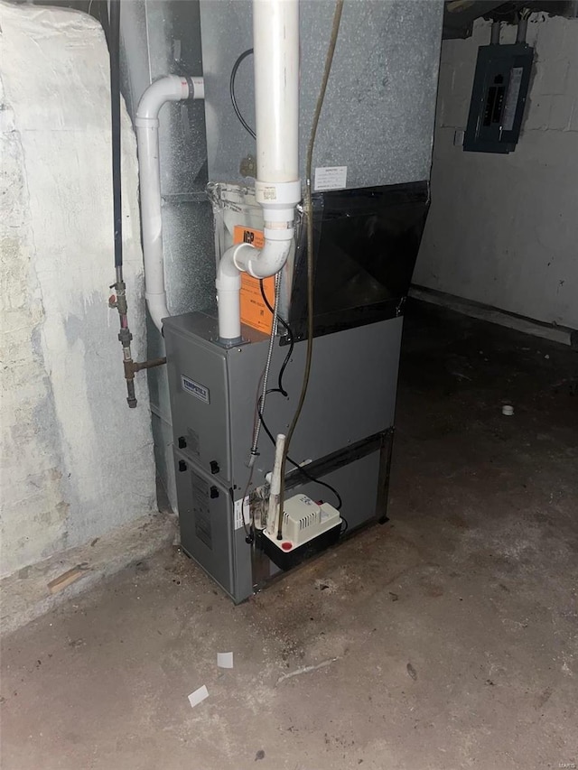 utility room featuring electric panel and heating unit