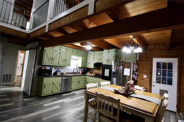 kitchen featuring sink, green cabinets, stainless steel appliances, a notable chandelier, and a barn door