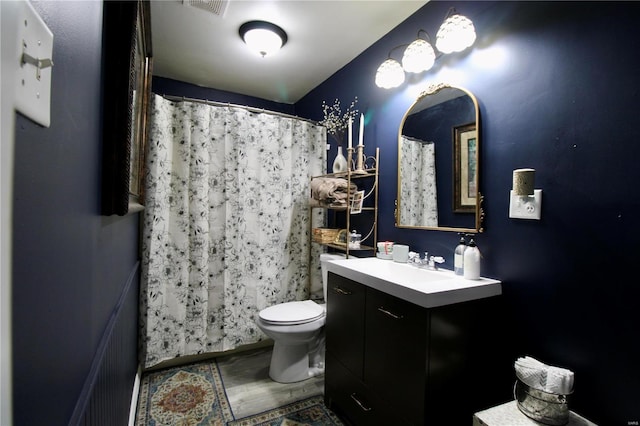 bathroom featuring walk in shower, vanity, and toilet