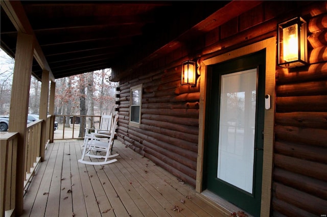 snow covered deck featuring a porch