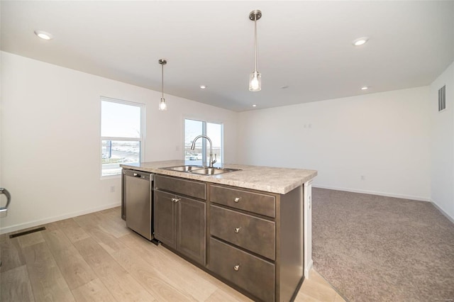 kitchen with pendant lighting, sink, dishwasher, a kitchen island with sink, and dark brown cabinets