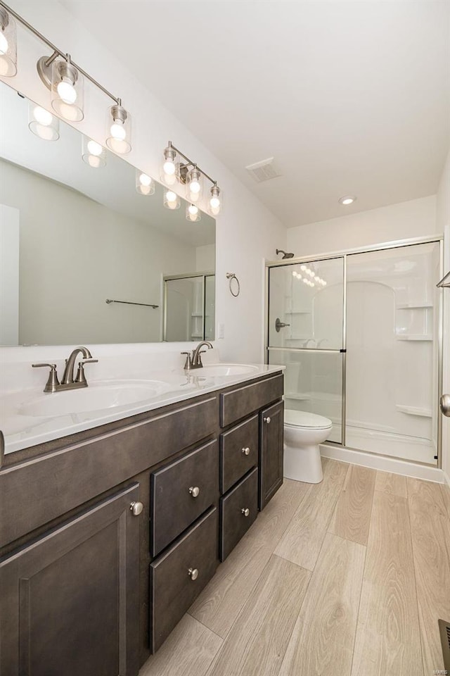 bathroom with vanity, an enclosed shower, and toilet