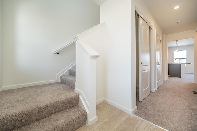 stairway with sink and carpet floors