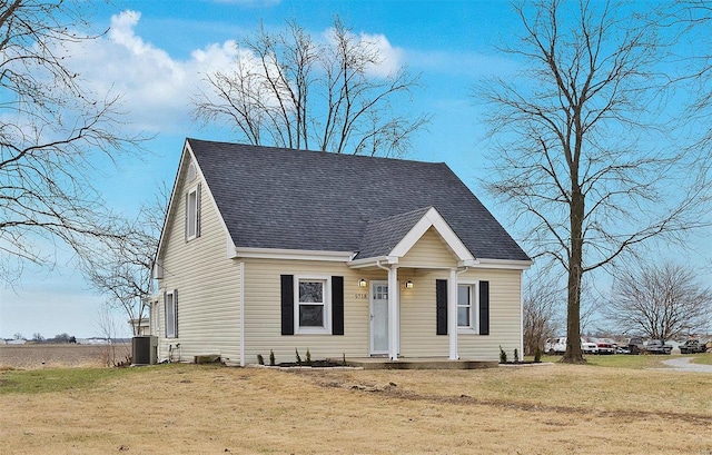 view of front of property featuring central AC unit and a front yard