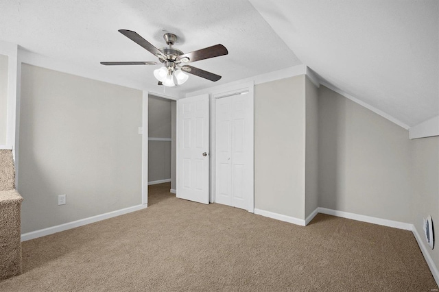 interior space featuring carpet flooring, ceiling fan, a textured ceiling, and lofted ceiling