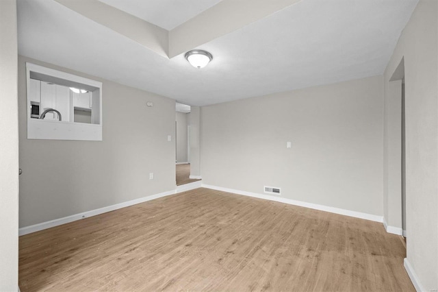 unfurnished room featuring light hardwood / wood-style floors and sink