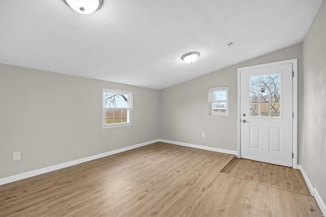 foyer entrance with light hardwood / wood-style floors and vaulted ceiling