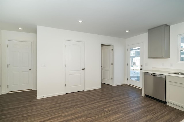 kitchen featuring dark hardwood / wood-style flooring, sink, stainless steel dishwasher, and gray cabinetry