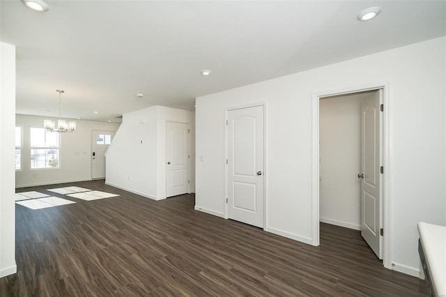 unfurnished living room with a chandelier and dark hardwood / wood-style flooring