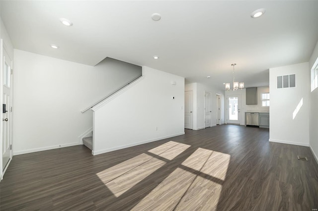 unfurnished living room with dark hardwood / wood-style flooring and a chandelier