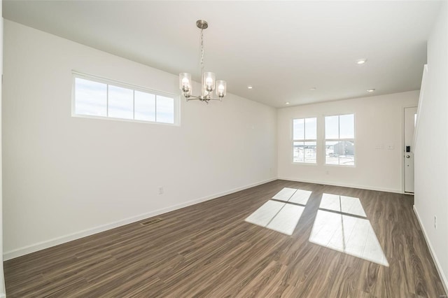 unfurnished room featuring dark wood-type flooring and a chandelier