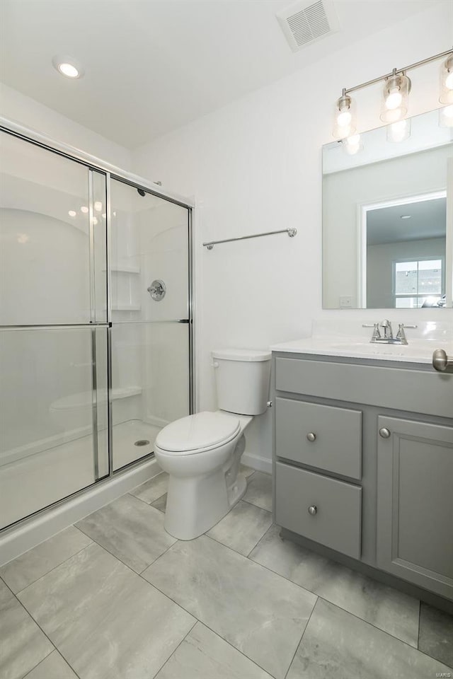 bathroom featuring vanity, toilet, and walk in shower