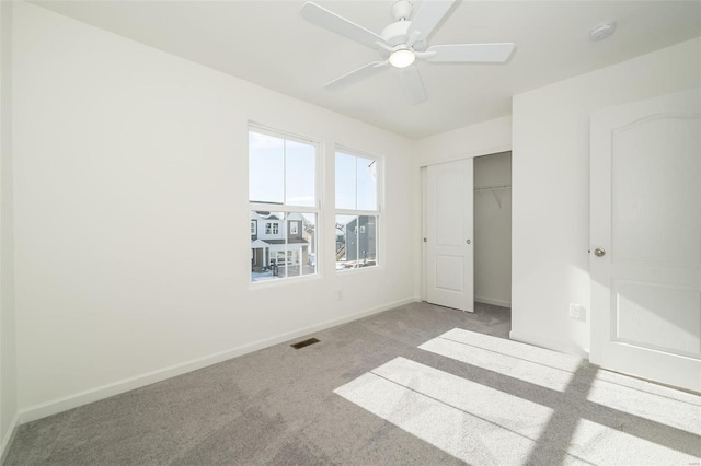 unfurnished bedroom featuring a closet, ceiling fan, and carpet