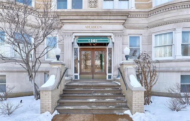 snow covered property entrance with french doors