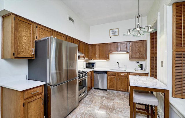 kitchen with visible vents, pendant lighting, a sink, appliances with stainless steel finishes, and light countertops