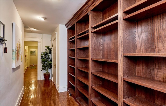 hall featuring baseboards and dark wood finished floors