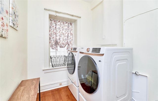 laundry area with laundry area, wood finished floors, and washer and clothes dryer