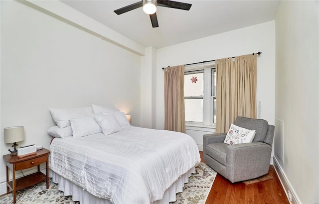 bedroom featuring a ceiling fan, wood finished floors, and baseboards