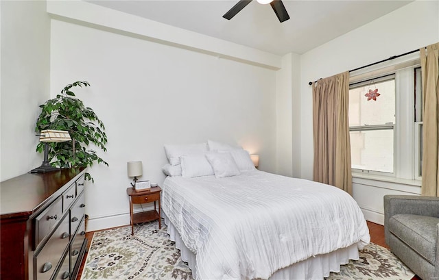 bedroom with ceiling fan, baseboards, and wood finished floors