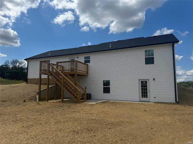 rear view of house featuring a deck and cooling unit