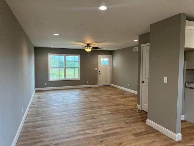 unfurnished living room with light wood-type flooring and ceiling fan