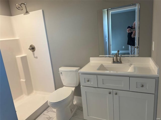 bathroom with toilet, walk in shower, and vanity