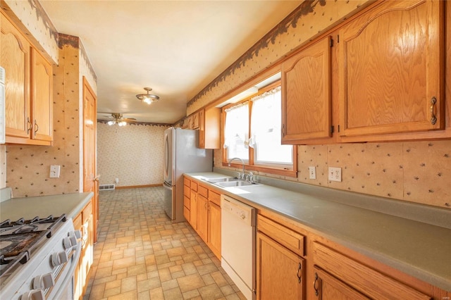 kitchen featuring ceiling fan, sink, and white appliances