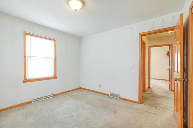 spare room featuring light colored carpet