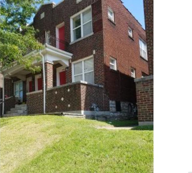 view of property exterior with a yard and a balcony