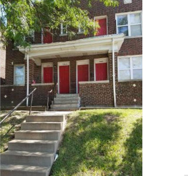 view of property with a porch and a front lawn