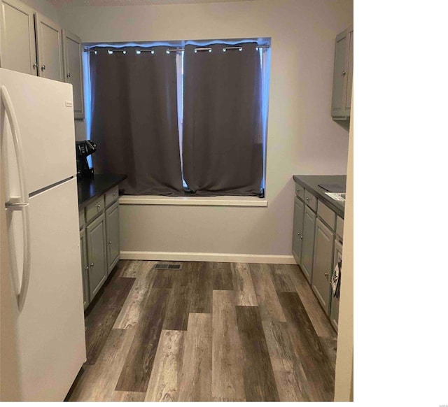 kitchen featuring gray cabinets, white fridge, and dark hardwood / wood-style floors