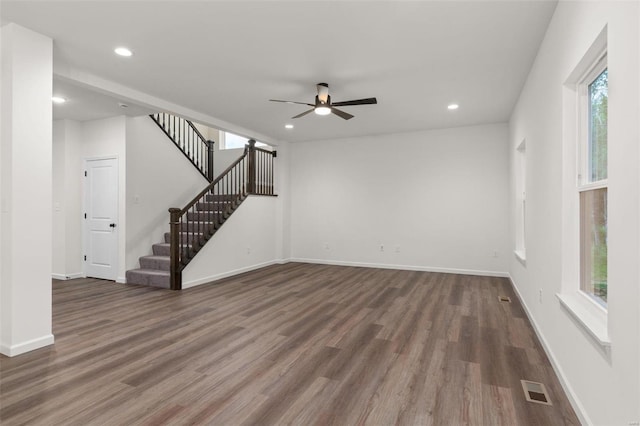 unfurnished living room with ceiling fan and dark wood-type flooring