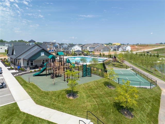 view of play area featuring tennis court and a lawn