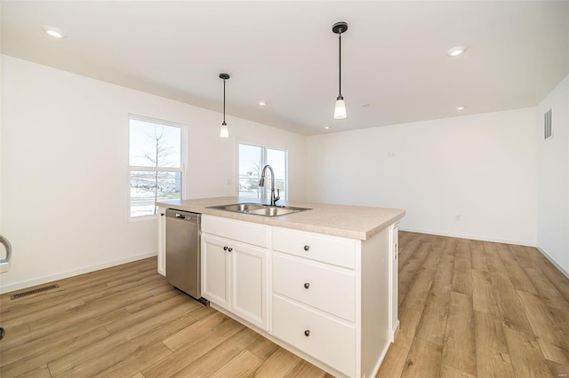 kitchen with sink, stainless steel dishwasher, an island with sink, pendant lighting, and white cabinets