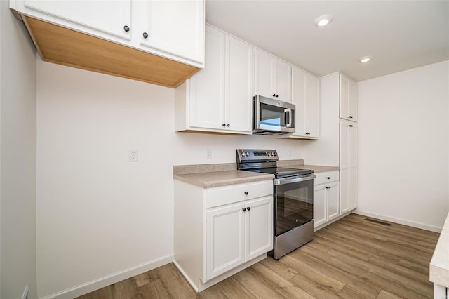 kitchen featuring white cabinetry, stainless steel appliances, and light hardwood / wood-style floors