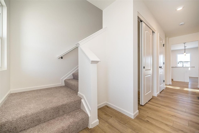 stairway with hardwood / wood-style flooring and sink