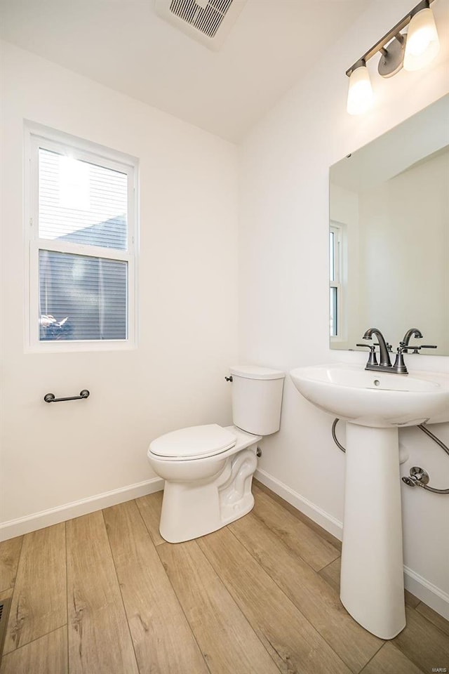 bathroom featuring wood-type flooring, toilet, and sink