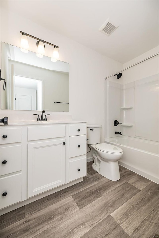 full bathroom featuring vanity, hardwood / wood-style floors, toilet, and shower / bath combination