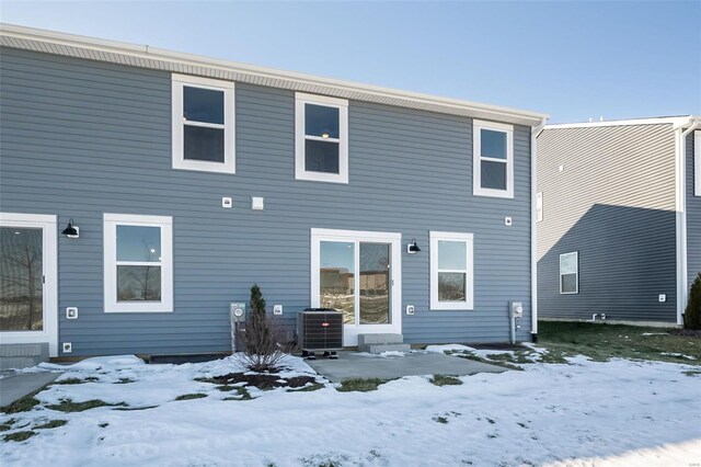 snow covered house featuring cooling unit