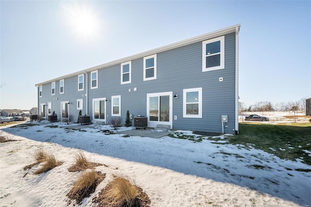 snow covered house featuring central air condition unit