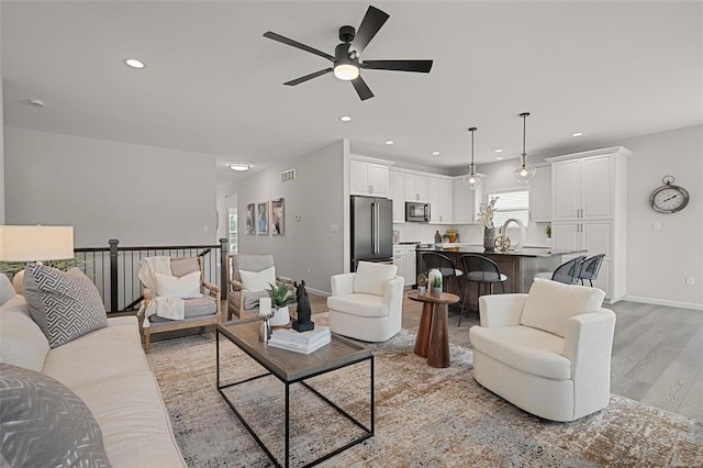 living room with light hardwood / wood-style floors and ceiling fan