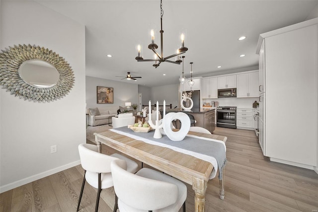 dining area featuring light hardwood / wood-style floors and ceiling fan with notable chandelier