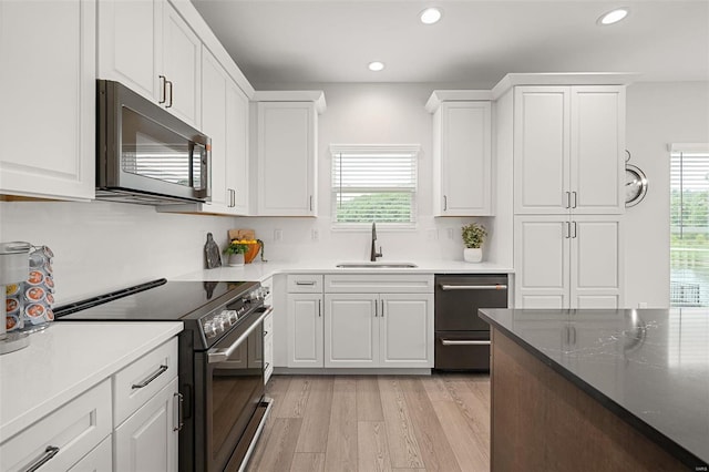 kitchen with white cabinets, stainless steel appliances, plenty of natural light, and sink