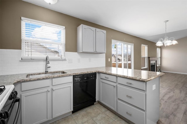 kitchen with black dishwasher, sink, decorative backsplash, kitchen peninsula, and gas range