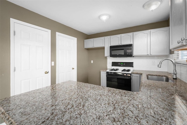 kitchen with sink, light stone counters, white cabinets, decorative backsplash, and range with gas cooktop