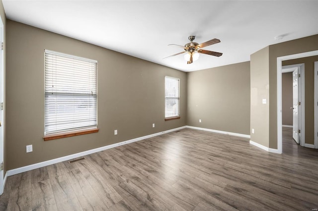 empty room featuring ceiling fan and dark hardwood / wood-style flooring