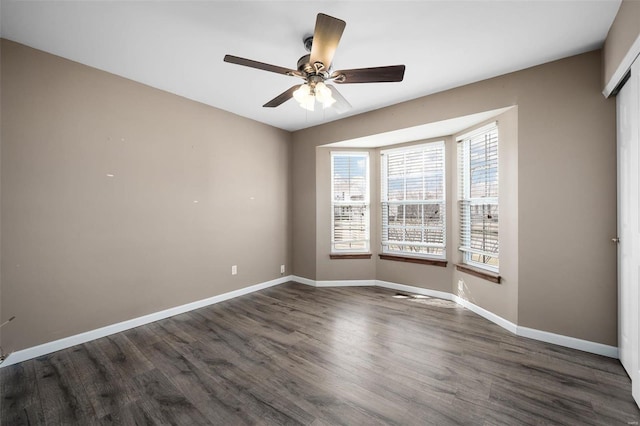 unfurnished room with ceiling fan and dark hardwood / wood-style flooring