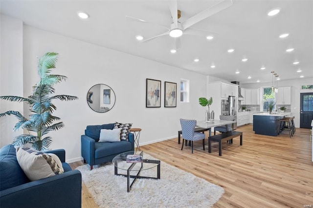 living area with light wood finished floors, recessed lighting, baseboards, and ceiling fan